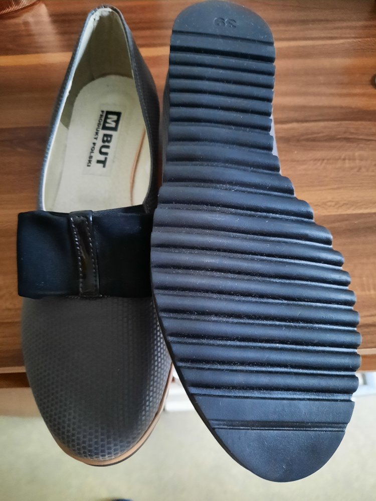 Graue flache Schuhe mit schwarzer schleife auf dem span 